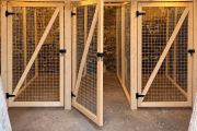 Three timber-mesh cages in stone cellar.png